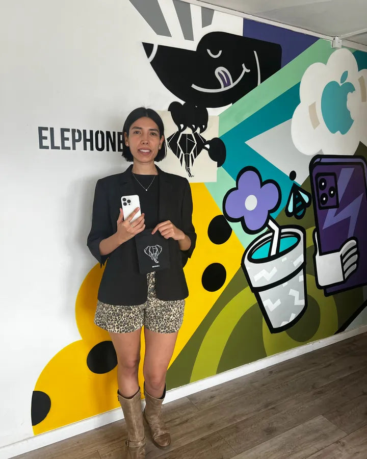 Clienta con su iPhone y la bolsa de Elephone frente al mural