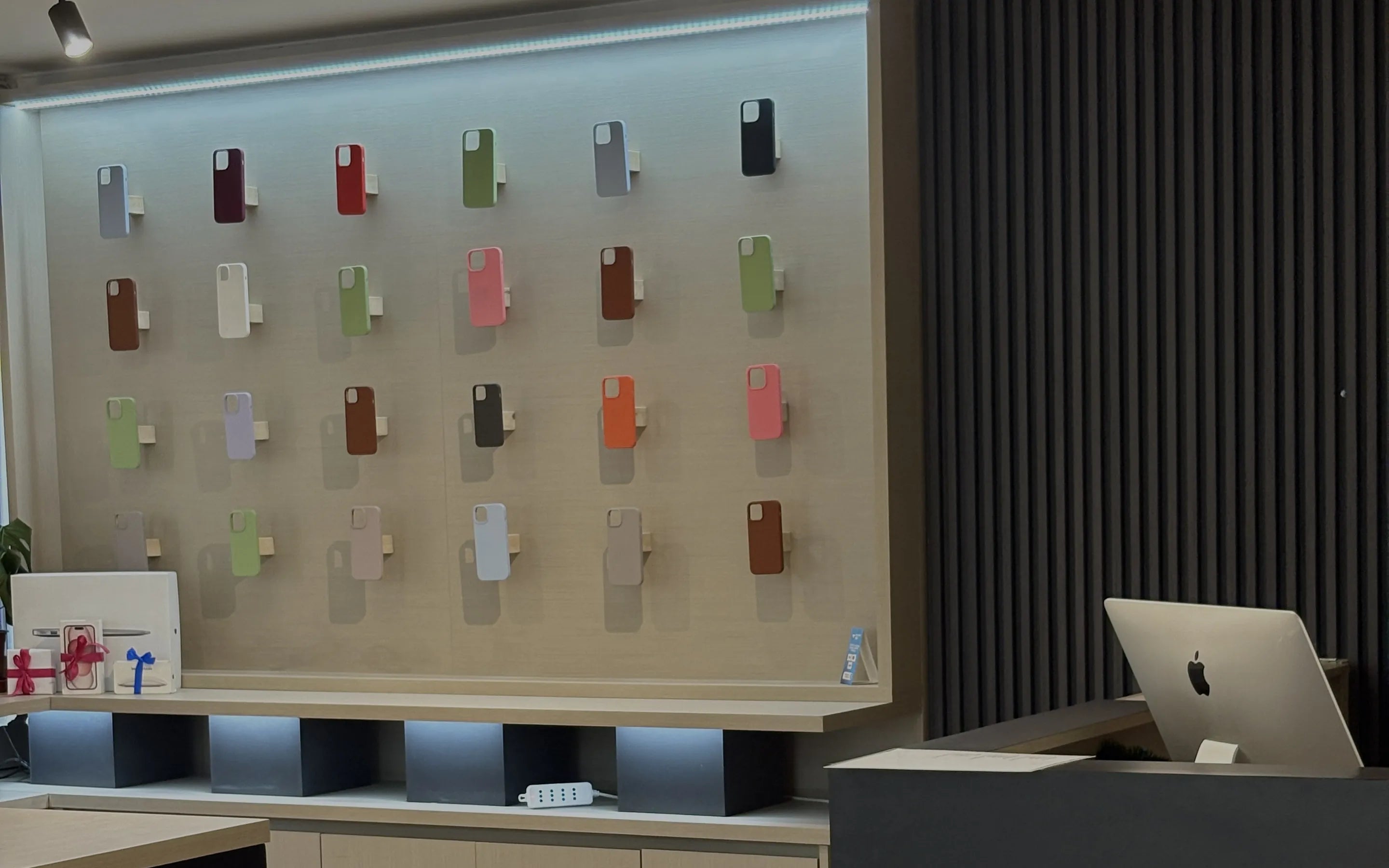 Muro de carcasas y mesón de atención del showroom