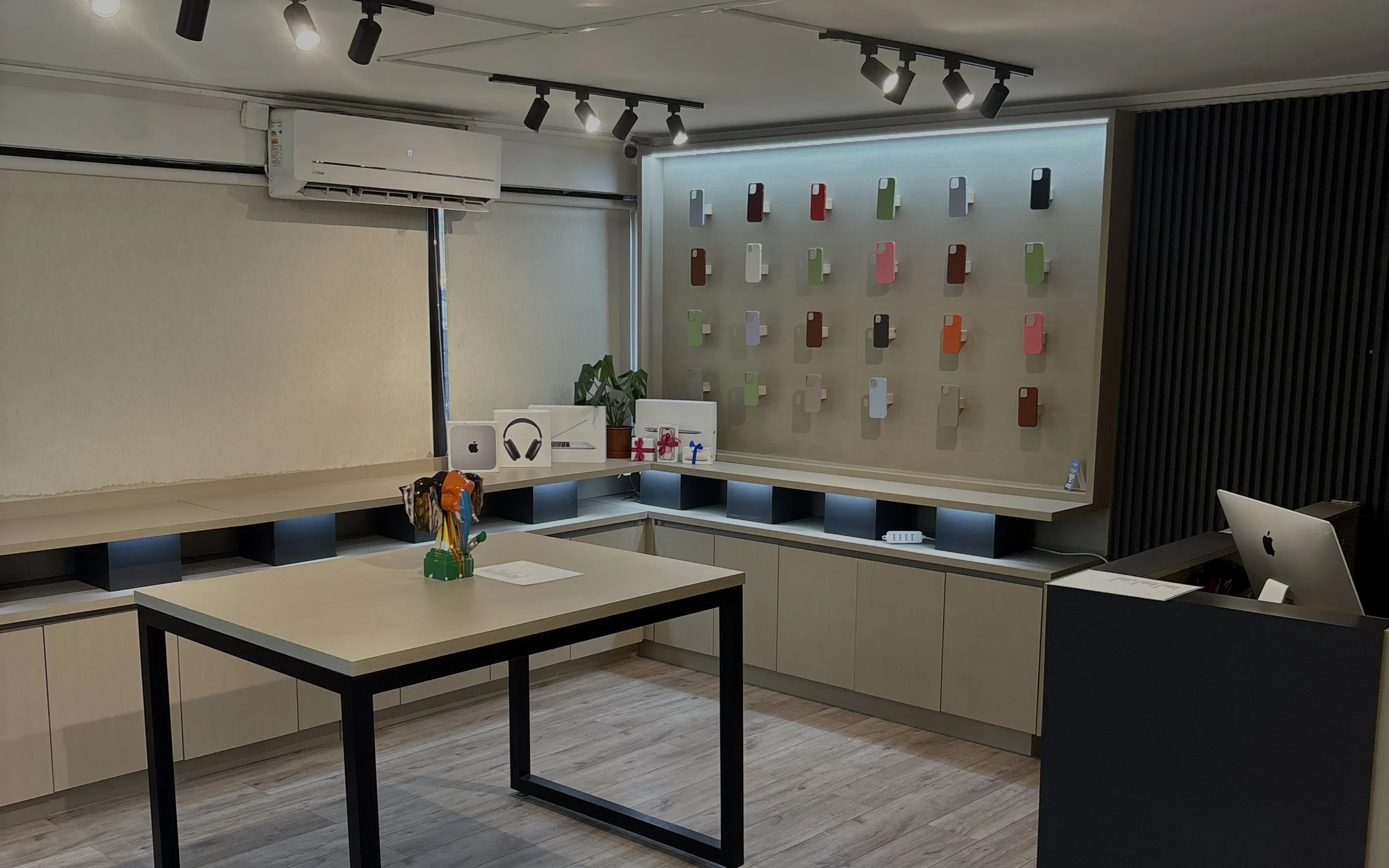 El showroom de Elephone: mesa para probar los equipos, muro de carcasas y mesón de atención